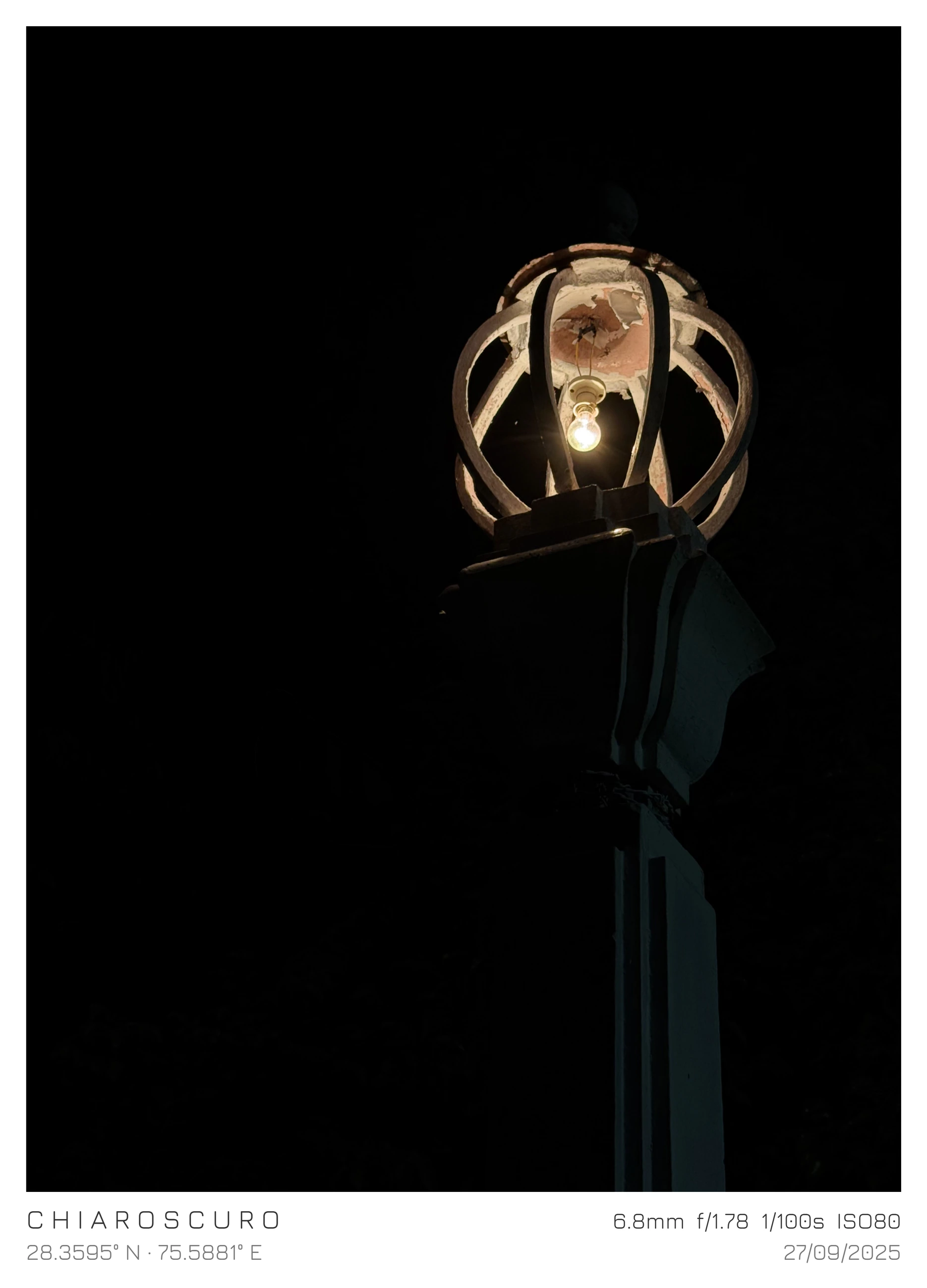 A warm lamp suspended inside a sculptural metal cage