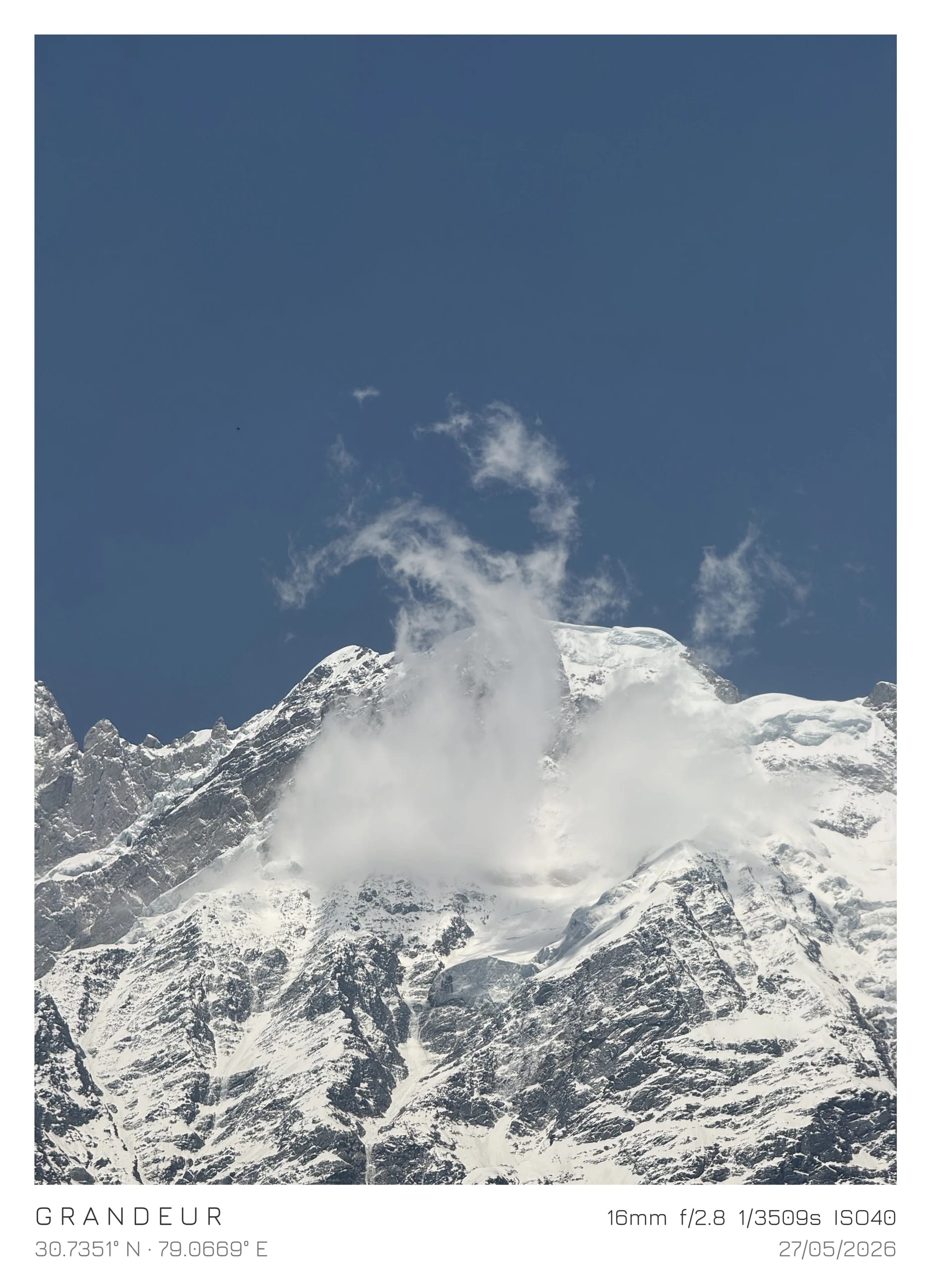 A snowy mountain summit beneath a blue sky