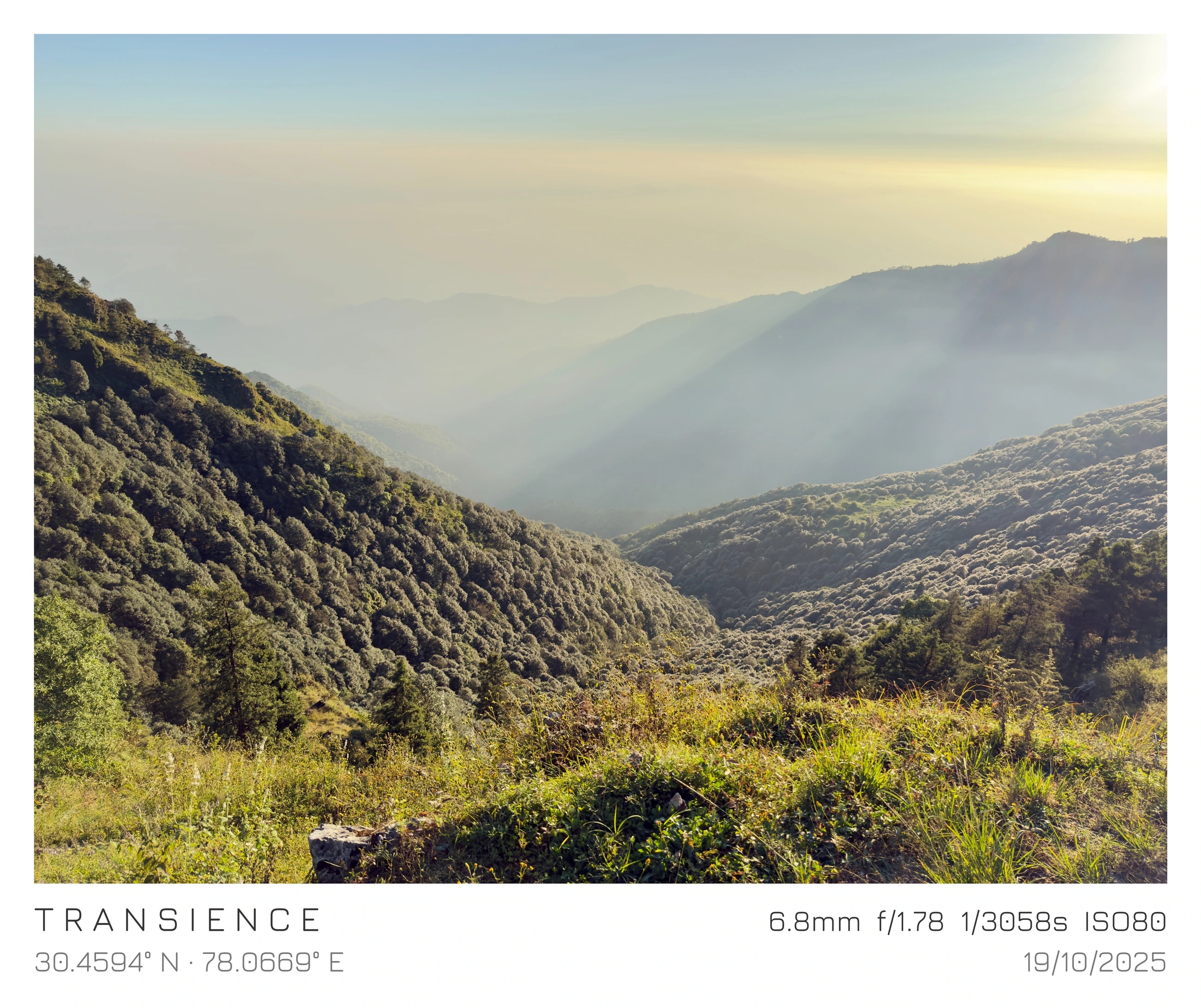 Sunlight spilling across layered green mountain valleys